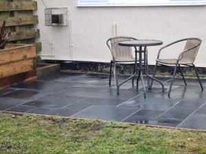 a patio with two chairs and a table and a table and chairs at Seaview in Trevilley
