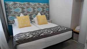 sypialnia z łóżkiem z żółtymi i niebieskimi poduszkami w obiekcie Sofía w mieście Benidorm