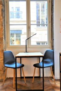 uma mesa com duas cadeiras e um candeeiro em Le Blue - hypercentre - Presque île em Lyon