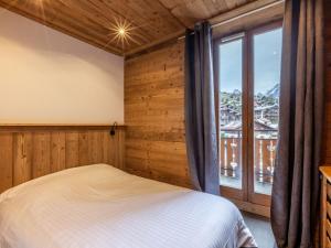 a bedroom with a bed and a large window at Appartement La Clusaz, 4 pièces, 8 personnes - FR-1-437-3 in La Clusaz