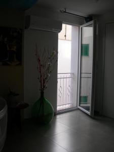 un vase avec des fleurs dans une pièce avec une porte ouverte dans l'établissement Capri house, à Fasano