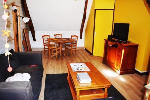 ein Wohnzimmer mit einem Sofa und einem Tisch in der Unterkunft Appartement la Roche Bernard in La Roche-Bernard