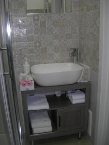 un bagno con lavandino e asciugamani su una mensola di Capri house a Fasano