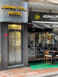 an asian pera hotel with tables and chairs in the window at Asmali Pera Hotel in Istanbul