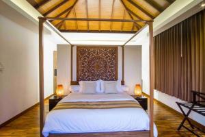 1 dormitorio con 1 cama con dosel y 2 lámparas en Paanchali Ocean View Villa near Melasti Beach, en Nusa Dua 19 fotos más