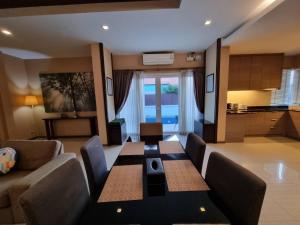 ein Wohnzimmer mit einem Tisch und einer Küche in der Unterkunft Midas Pool Villa in Jomtien Beach