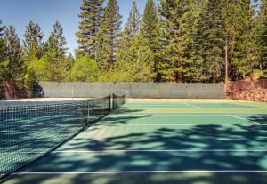 una pista de tenis con una red y árboles en el fondo en Kingswood Village 60, en Kings Beach