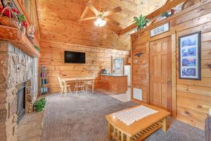 una sala de estar con chimenea y una mesa en una cabaña en Wildwood, en Pigeon Forge