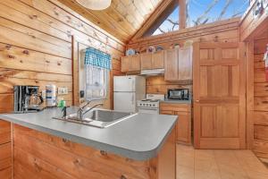 a kitchen with a sink and a refrigerator at Wildwood in Pigeon Forge +20 photos