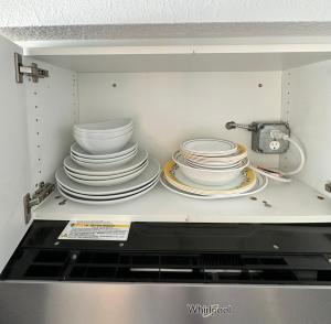 a pile of plates sitting on top of a microwave at Daytona Beach Resort Private balcony Ocean Front in Daytona Beach