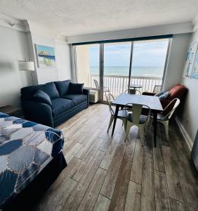 a living room with a couch and a table with a view of the ocean at Daytona Beach Resort Private balcony Ocean Front in Daytona Beach