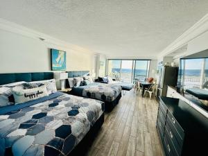 Daytona Beach Resort Private balcony Ocean Front في دايتونا بيتش: غرفه فندقيه بسرير واريكه