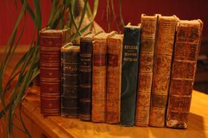 un groupe de vieux livres assis sur une table dans l'établissement Hotel Boileau, à Paris