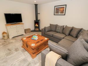 a living room with a couch and a tv at The Granary in Bridgend