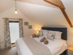 a bedroom with a large white bed with a window at The Granary in Bridgend