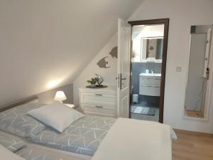 a bedroom with a bed and a bathroom with a sink at Mellum in Norden