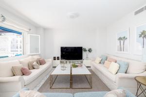 salon z białymi meblami i telewizorem z płaskim ekranem w obiekcie Beautiful 2 Bed Playas del Duque + Parking RDR294 w Marbelli