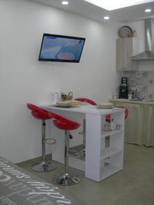 una cucina con bancone bianco e sgabelli rossi di Capri house a Fasano