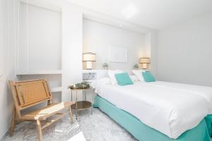 biała sypialnia z dużym łóżkiem i krzesłem w obiekcie Beautiful 2 Bed Playas del Duque + Parking RDR294 w Marbelli