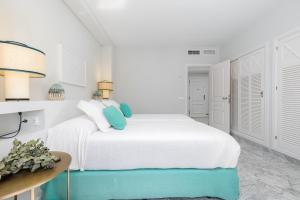 biała sypialnia z białym łóżkiem z niebieskimi akcentami w obiekcie Beautiful 2 Bed Playas del Duque + Parking RDR294 w Marbelli