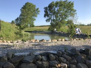 uno stagno in un campo con rocce intorno di Szalowa Sport Arena a Szalowa