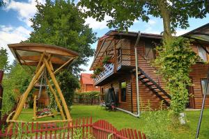 a house with a staircase and a yard with red chairs at Casa Bunicii in Costeşti