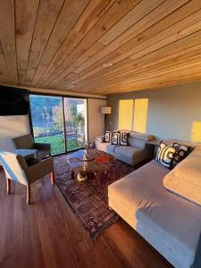 Habitación con cama, sofá y mesa. en Hermosa casa privada con jacuzzi y una vista espectacular al lago en Valle de Bravo