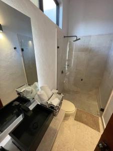 La salle de bains est pourvue d'une douche et de toilettes. dans l'établissement Hermosa casa privada con jacuzzi y una vista espectacular al lago, à Valle de Bravo