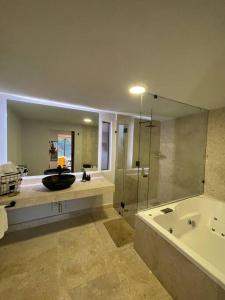 a bathroom with a tub and a sink and a shower at Hermosa casa privada con jacuzzi y una vista espectacular al lago in Valle de Bravo