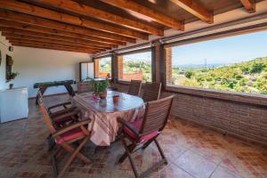 una sala da pranzo con tavolo, sedie e finestre di Cortijo La Cañada by Solset a Torrox