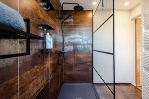 La salle de bains est pourvue d'une douche avec une porte en verre. dans l'établissement Sunnyzandvoort, à Zandvoort