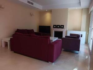 ein Wohnzimmer mit einem lila Sofa und einem Kamin in der Unterkunft Modern villa in Marbella with private pool in Marbella