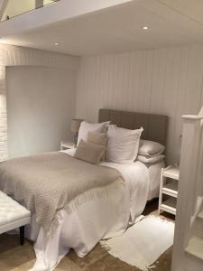 um quarto branco com uma cama grande e almofadas em Harcombe Barn near Bristol em Bristol
