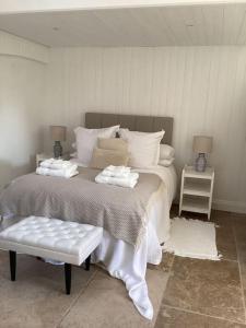 a bedroom with a large bed with a bench in it at Harcombe Barn near Bristol in Bristol