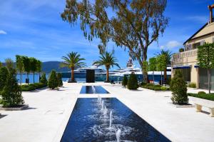 a fountain in a park with a cruise ship in the background at Apartments Villa Milna 1 in Budva