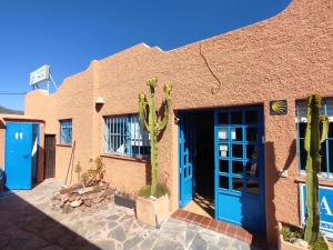 a building with blue doors and cactus in front of it at Albergue de San Jose in San José