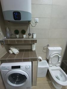 a small bathroom with a washing machine and a toilet at Guesthouse BiT Accommodation in Kotor