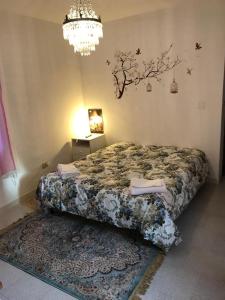 1 dormitorio con cama y lámpara de araña en CASA VACANZE ROSA BLU, en Giffoni Valle Piana