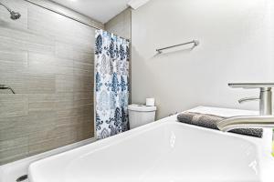 a bathroom with a white tub and a sink at Bay Street Bliss in Gulf Breeze +16 photos