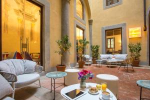 a patio with couches and tables and chairs at Casual Rinascimento Firenze in Florence