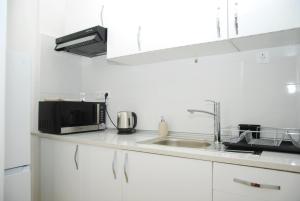 a kitchen counter with a microwave and a sink at Amor Lisboa Hostel in Lisbon