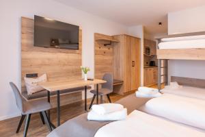 Zimmer mit 2 Betten, einem Tisch und Stühlen in der Unterkunft Hotel Gasthof Sonnenhang in Denkendorf