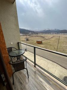 balkon ze stołem i widokiem na pole w obiekcie Villa Deluxe Premium Apartment 308 w mieście Bakuriani