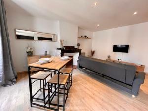 a dining room with a table and a couch at Spacieux Appartement Lumineux Cœur De Ville in Pamiers