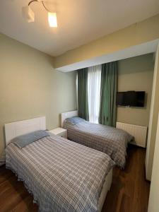 2 łóżka w małym pokoju z oknem w obiekcie Villa Deluxe Premium Apartment 308 w mieście Bakuriani