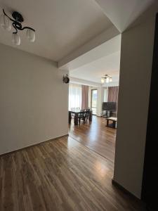 an empty living room with wooden floors and a piano at Villa Deluxe Premium Apartment 308 in Bakuriani