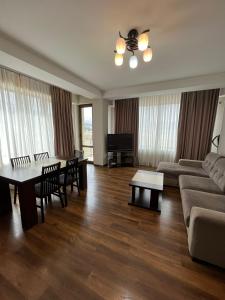 salon z kanapą i stołem w obiekcie Villa Deluxe Premium Apartment 308 w mieście Bakuriani