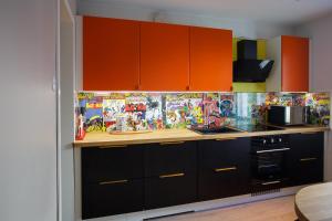 una cucina con armadi arancioni e piano di lavoro di Hannula a Kuopio