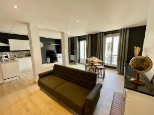 Spacieux Appartement Lumineux Cœur De Ville في بامييه: غرفة معيشة مع أريكة ومطبخ