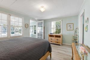 a bedroom with a bed and two windows at Beach Cottage on Jones in Tybee Island